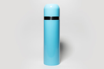 Close-up of blue steel thermos on grey studio background.