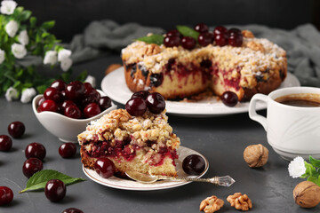 Piece homemade cherry pie with shtreisel and walnuts on white plate on a dark concrete background