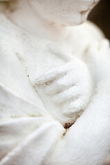 Hands on the chest. Old sculpture.