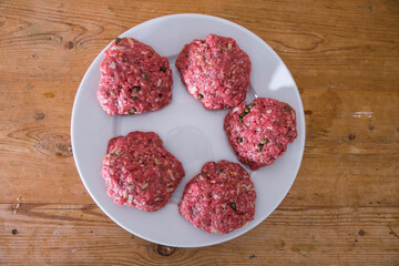 Raw hamburgers on a plate.