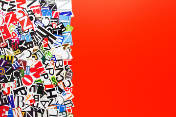 Fototapeta na wymiar Alphabet letters cutting from paper magazine on red background with copy space for text. Abstract collage from clippings with newspaper magazine letters.