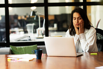 Portrait of tired businesswoman. Sad exhausted woman working on laptop in the office