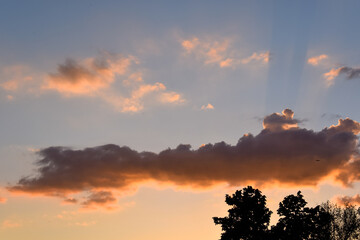 Naklejka na ściany i meble Evening clouds illuminated by the evening sun