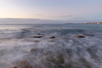 Flowing wave water on the beach during high tide.