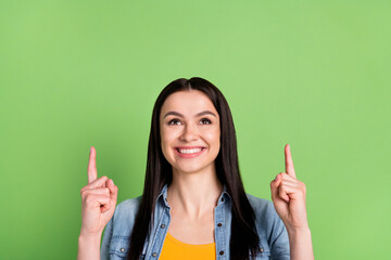 Photo of optimistic cute brown long hairdo lady point look empty space wear jeans shirt isolated on...