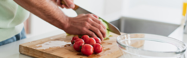 cropped view of man cutting fresh cherry tomatoes near bowl, banner