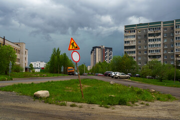Road closed for repair work on outskirts of city and storm clouds above it