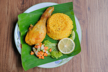 Nasi Arab Mandy with chicken Mandy spice and mix pickled vegetables on banana leaf . Middle East Cuisine.