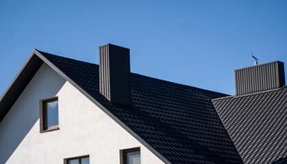 Grey corrugated metal profile roof installed on a modern house. The roof of corrugated sheet. Roofing of metal profile wavy shape. Modern roof made of metal. Metal roofing.