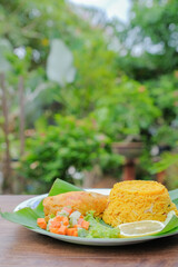 Nasi Arab Mandy with chicken Mandy spice and mix pickled vegetables on banana leaf . Middle East Cuisine.