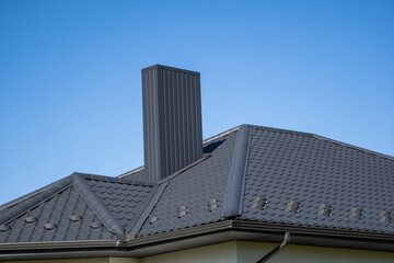 Grey corrugated metal profile roof installed on a modern house. The roof of corrugated sheet. Roofing of metal profile wavy shape. Modern roof made of metal. Metal roofing.