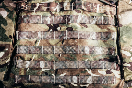 Photo of military camouflaged armored vest molle system.