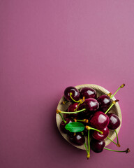 ripe cherries on bowl on pink background. top view. Food concept
