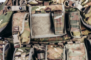 Close-up photo of multi camouflaged soldier vest pouches system.