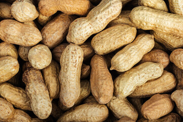 Photo of peanuts in shell laying on surface close-up photo.