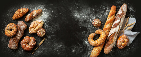 Bakery - bread rolls, baguette, bagel, sweet bun and croissant on black background - obrazy, fototapety, plakaty