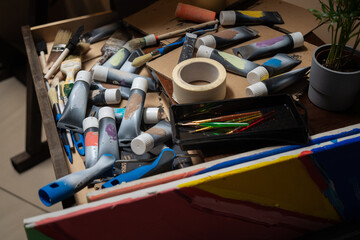 Drawer,cabinet of the artist, painter with scattered, disordered paints in a tube, paint brushes,...