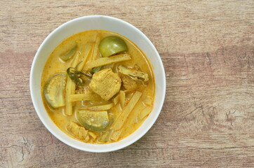 spicy boiled slice fresh bamboo shoot and eggplant with chicken in coconut milk curry soup on bowl