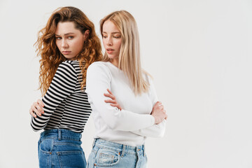 Young two women standing back to back after argument