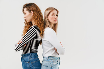 Young two women standing back to back after argument