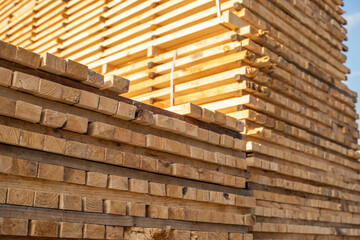 Storage of piles of wooden boards on the sawmill. Boards are stacked in a carpentry shop. Sawing drying and marketing of wood. Pine lumber for furniture production, construction. Lumber Industry.