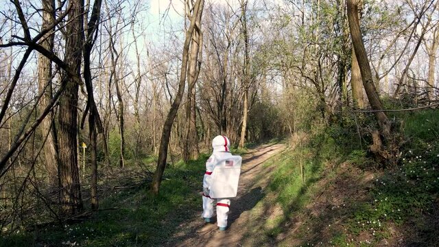 Astronaut exploring forest, walking on dirt track