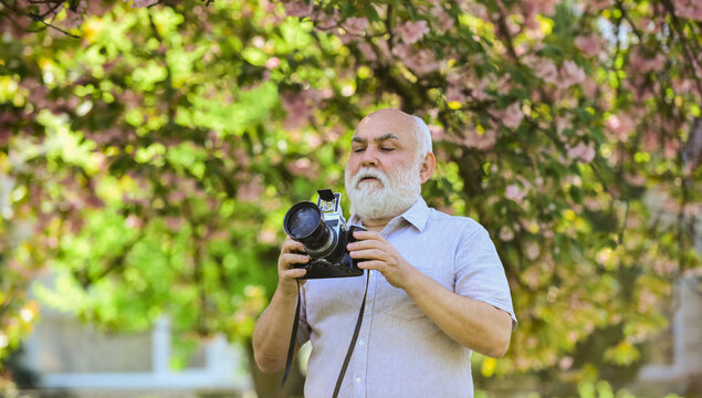 Warm day. Cherry blossoming garden. photographer taking photos of famous cherry blossoms. spring season with full bloom pink flower. photographer man take sakura cheery blossom photo