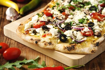 Fresh homemade pizza slice with feta cheese, arugula, olive, tomato, red onion, garlic and chili - 436026318