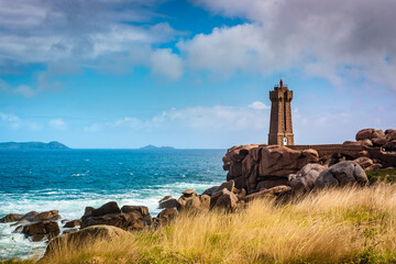 Fototapeta na wymiar Men Ruz lighthouse made of pink granite is a symbol of the Brittany coast