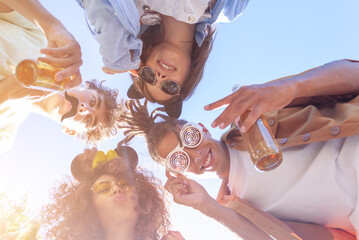 People stay in circle enjoying refreshing beverage. Young men and women drink beer on festival, birthday. Happy friends spending free time together in park sitting on grass, drinking beer and chatting