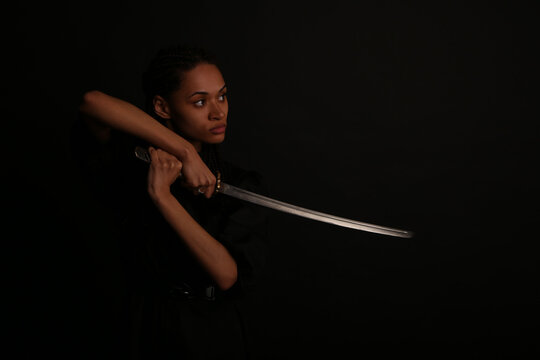Woman in black dress holding a katana sword