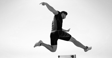 Composition of male hurdle jumper with copy space in black and white