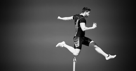 Fototapeta na wymiar Composition of male hurdle jumper with copy space in black and white