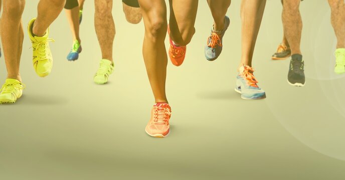 Composition of legs of athletes running on racing track with spots of light