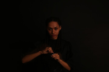 Portrait of beautiful curly woman on black background