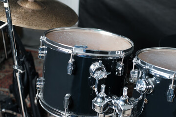 Fototapeta na wymiar modern drum set in a rehearsal room. music equipment for stage and studio performance. black drum kit