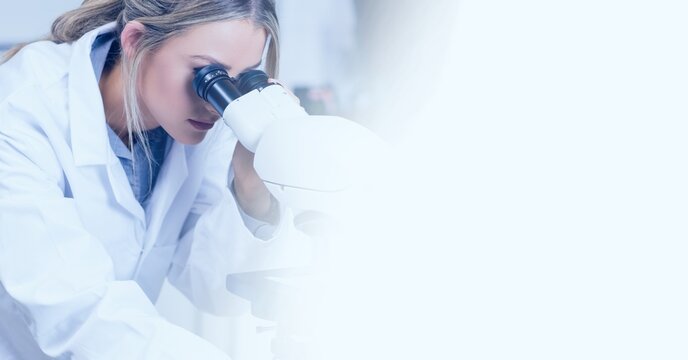 Composition of female lab technician using microscope, with white blurred copy space to right