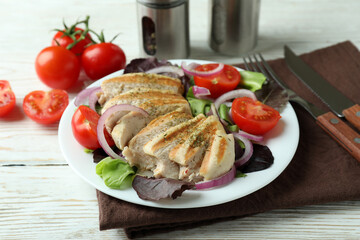 Salad with grilled chicken on white wooden table