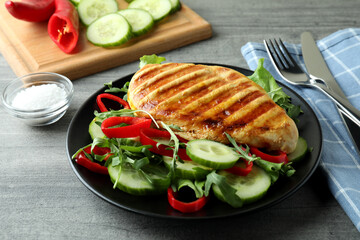 Salad with grilled chicken on gray textured table