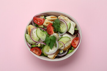 Salad with grilled chicken on pink background