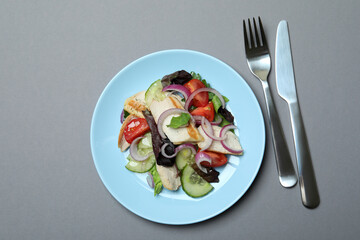 Concept of tasty eating with salad with grilled chicken on gray background