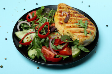 Salad with grilled chicken on blue background