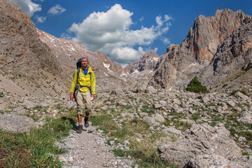 Naklejka premium A man with a large backpack walks high in the Aladaglar mountains. Turkey
