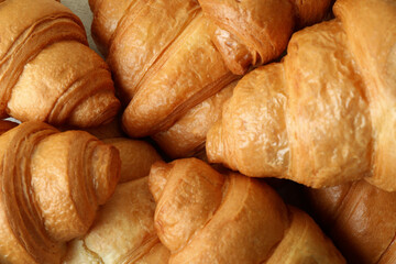 Fresh tasty croissants on whole background, close up