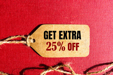 GET EXTRA 25 OFF percent text on a brown tag on a red paper background