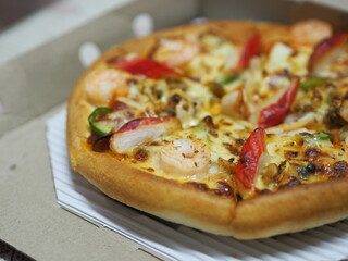 Pizza Seafood Cocktail pan on top with Shrimp, Crab Sticks, Ham, Pineapple and Sauce in paper box, fast food