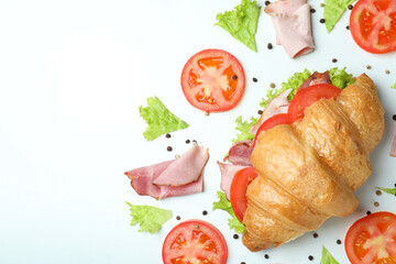 Croissant sandwich and ingredients on white background, space for text