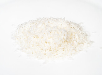 handful of coconut flakes closeup on white