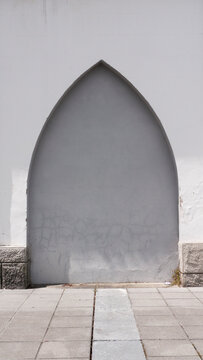 Arco apuntado ojival sellado en fachada gris