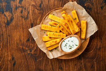 Homemade polenta chips fries with sea salt, parmesan, thyme, rosemary with yogurt sauce. Typical...